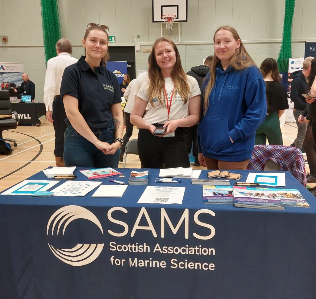 Student ambassador Anna is joined by two SAMS staff members who were also former undergrads at Oban High School career fair.